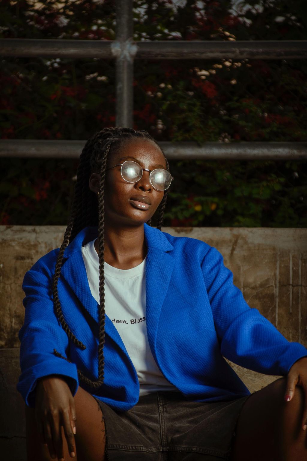 Styled editorial portrait of a creative in a blue jacket and round glasses, shallow depth of field